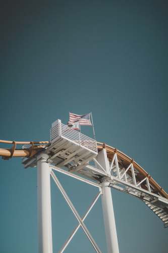 santa monica waving USA flag in roller coaster rail grey